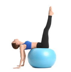 Fototapeta premium Sporty young woman training with fitball against white background