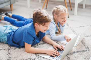 Cute little children with laptops at home. Concept of online education
