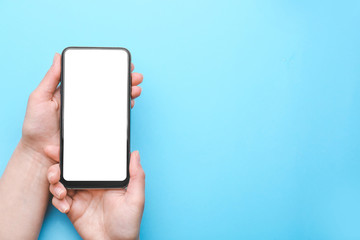 Female hands with mobile phone on color background