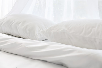 Fototapeta na wymiar Soft white linen on bed