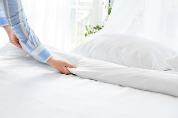 Woman making bed at home © Pixel-Shot