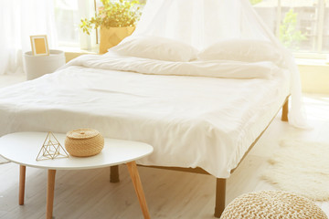 Big comfortable bed with clean linen in room