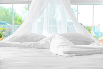 Big comfortable bed with clean linen in room © Pixel-Shot