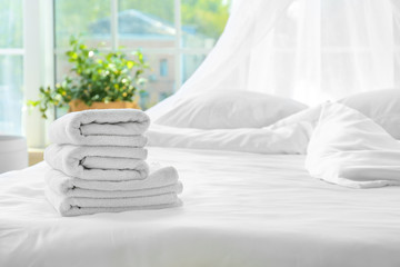 Clean towels on bed at home © Pixel-Shot