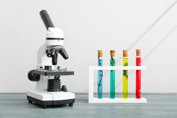 Modern microscope and test tubes on table