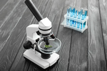 Modern microscope and test tubes on table