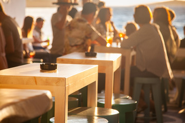 crowded restaurant by the beach at sunset