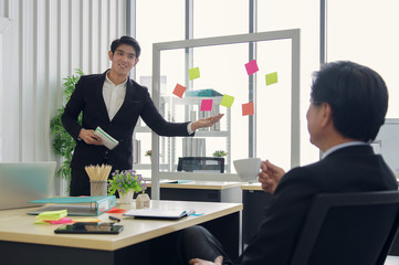 Asian smart young manager businessman is presenting a new project to senior manager in the meeting room at office