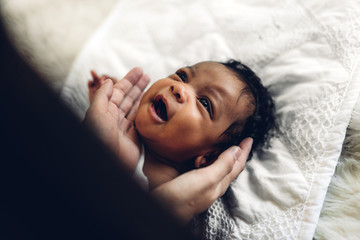 Fototapeta premium Portrait of enjoy happy love family african american mother playing with adorable little african american baby.Mom touching with cute son moments good time in a white bedroom.Love of black family