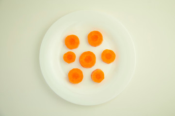 sliced fresh carrots in circles on a white background