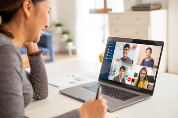 Young Asian businesswoman work at home and virtual video conference meeting with colleagues...