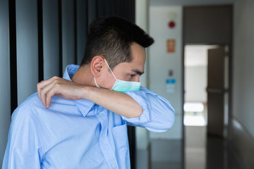 A young businessman wearing mask a face prevent the spread of the Covid-19 virus  while coughing, sneezing in office.