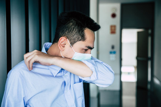 A young businessman wearing mask a face prevent the spread of the Covid-19 virus  while coughing, sneezing in office.