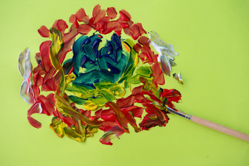 Colorful Paint mix against green background with brush on side