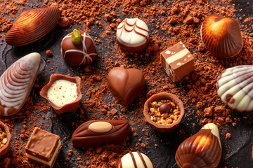 Belgian chocolate assortment, many different bonbons on a dark background