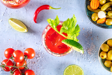 Bloody Mary cocktail with tomato juice, lime and celery, with pickles and olives, shot from the top