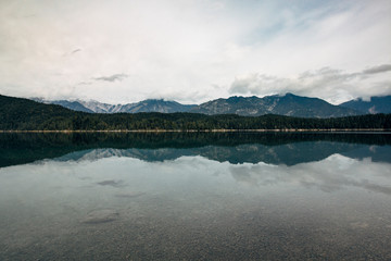 The hills around Eibsee reflected as a mirror image on the surface of the lake.