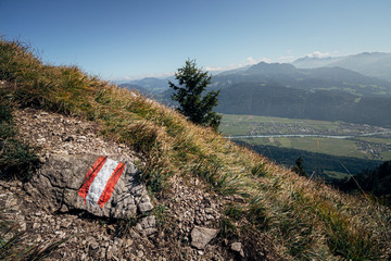 Trail marker in the Austrian alps with the Inntal valley visible in the distance