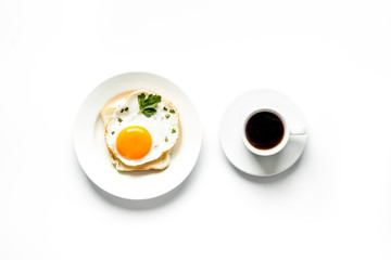 Fried eggs sandwich on plate - white dinner table top view