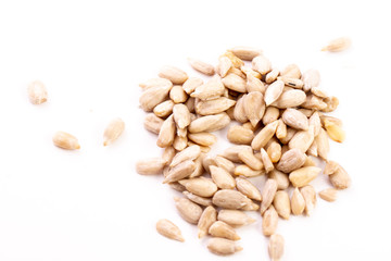 heap of peeled sunflower seeds, closeup, isolated on a white background. 