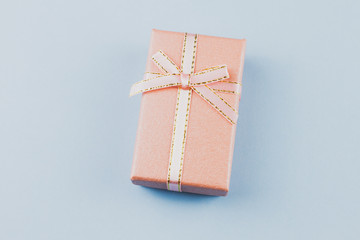 small gift on a pastel background, closeup. Gift box with a bow