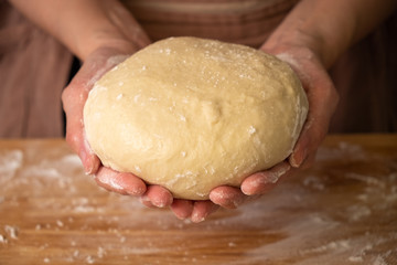 chef preparing bread dough on wooden table in a bakery.
