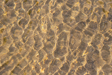 Klares Wasser einer sprudelnden Quelle mit Wasserpflanzen und klarer Bach mit seidigen Wellen für Entspannung und Meditation zeigen schöne Reflexionen auf der Wasseroberfläche mit unberührter Natur