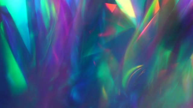 Holographic neon purple abstract background. The surface of the crystals and prism. Sparkling highlights and rainbow colors