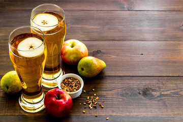 Glasses of beer with apple and peer on wooden table copy space