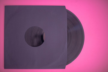 Vinyl record in sleeve isolated against pink background