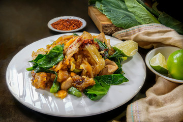 Fried big noodle with pork and Chinese kale with ingredients, Thai cooking and restaurant food