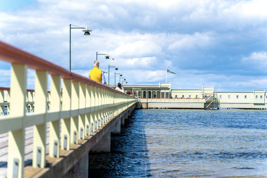 Malmo, sweden - 09 June 2019: Ribersborgs open-air bath, wooden pier in the Baltic Sea with walking people