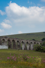 Obraz premium Aqueduct Los Arcos Tepotzotlán, Mexico October 07 2018 A wide arched passageway in the back of the complex leads to the extensive gardens area of more than 3 hectares, filled with gardens,