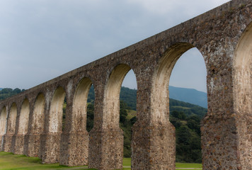 Fototapeta na wymiar Aqueduct Los Arcos Tepotzotlán, Mexico October 07 2018 A wide arched passageway in the back of the complex leads to the extensive gardens area of more than 3 hectares, filled with gardens,