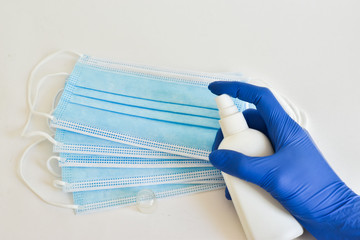 stop the global pandemic COVID-19. Coronavirus surgical masks and disinfecting gel for protection, hand hygiene. antiviral, respiratory bandage on the face on a blue background.