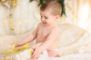 little happy kid unwraps  or opens boxes with gifts, surprises