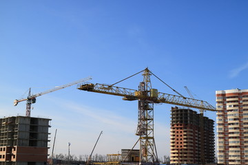 Tower cranes are working on the construction of a new house. Lifting crane.