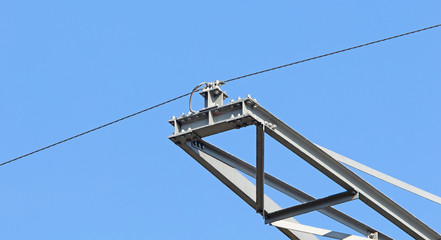 High-voltage electricity pylon against blue sky