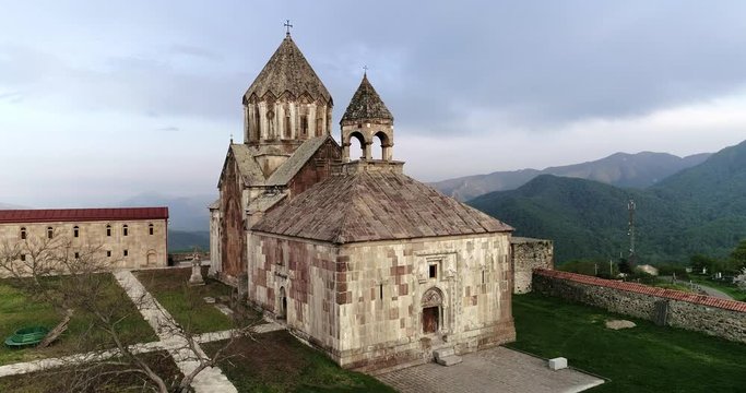 aerial unveiling shot of village in valley after monastery.  
