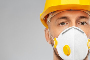 profession, construction and building - male worker or builder in helmet and respirator mask over grey background - obrazy, fototapety, plakaty
