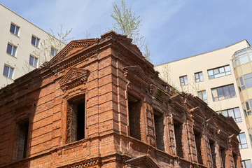 Fototapeta na wymiar dilapidated vintage house on the background of a modern building