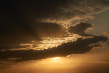 Fototapeta premium A beautiful evening blue sky at sunset with flaming bright light clouds. Warm evening.