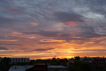 A beautiful evening blue sky at sunset with flaming bright light clouds. Warm evening.