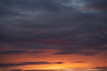 Fototapeta premium A beautiful evening blue sky at sunset with flaming bright light clouds. Warm evening.