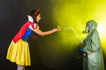Woman wearing a fairy tale dress holding an apple with radiation symbol. Environmental problems...
