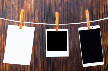 Photo templates hanging on a rope, secured with pegs. Photo concept reflecting evolution. Film photography, snapshot, digital. Colour image.