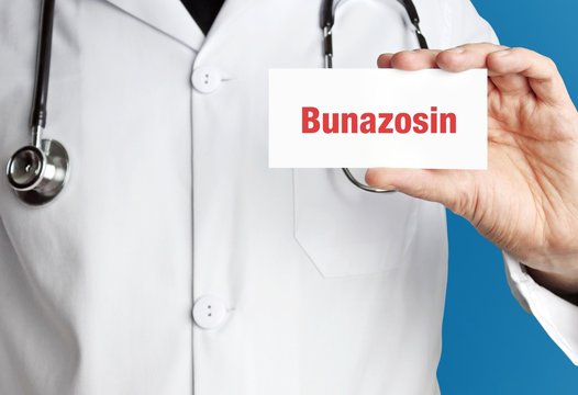 Bunazosin. Doktor mit Stethoskop (isoliert) zeigt Karte. Hand hält Schild mit Text. Blauer Hintergrund. Medizin, Gesundheitswesen
