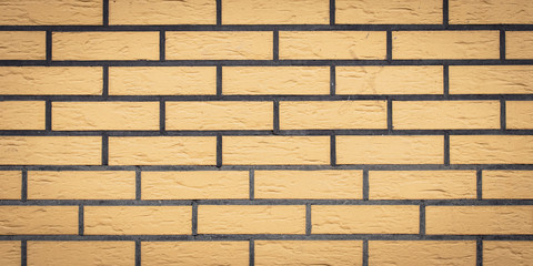 Brick wall texture, stone background. Yellow bricks pattern. Wide panorama, panoramic banner. Architecture facade, tiled surface, rock frame.