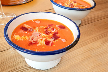 Salmorejo, Spanish cold tomato soup in a rustic bowl on a wooden table