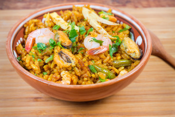 Cooked seafood paella in bowl close-up in selective focus